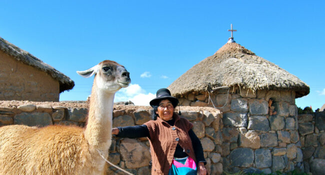 Frau mit Lama vor Haus